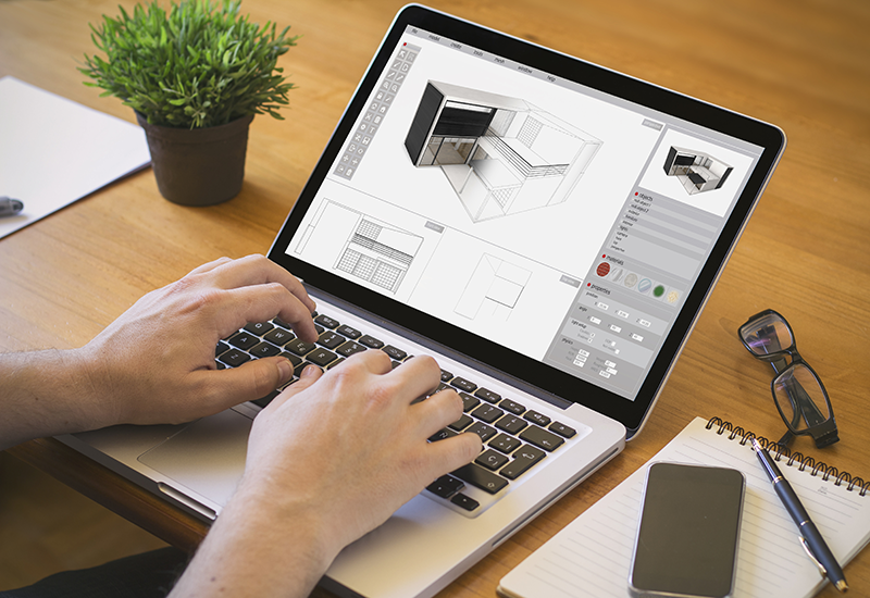 An architect at a brown desk working on a BIM structure for a building design in CAD software An architect at a brown desk working on a BIM structure for a building design in CAD software