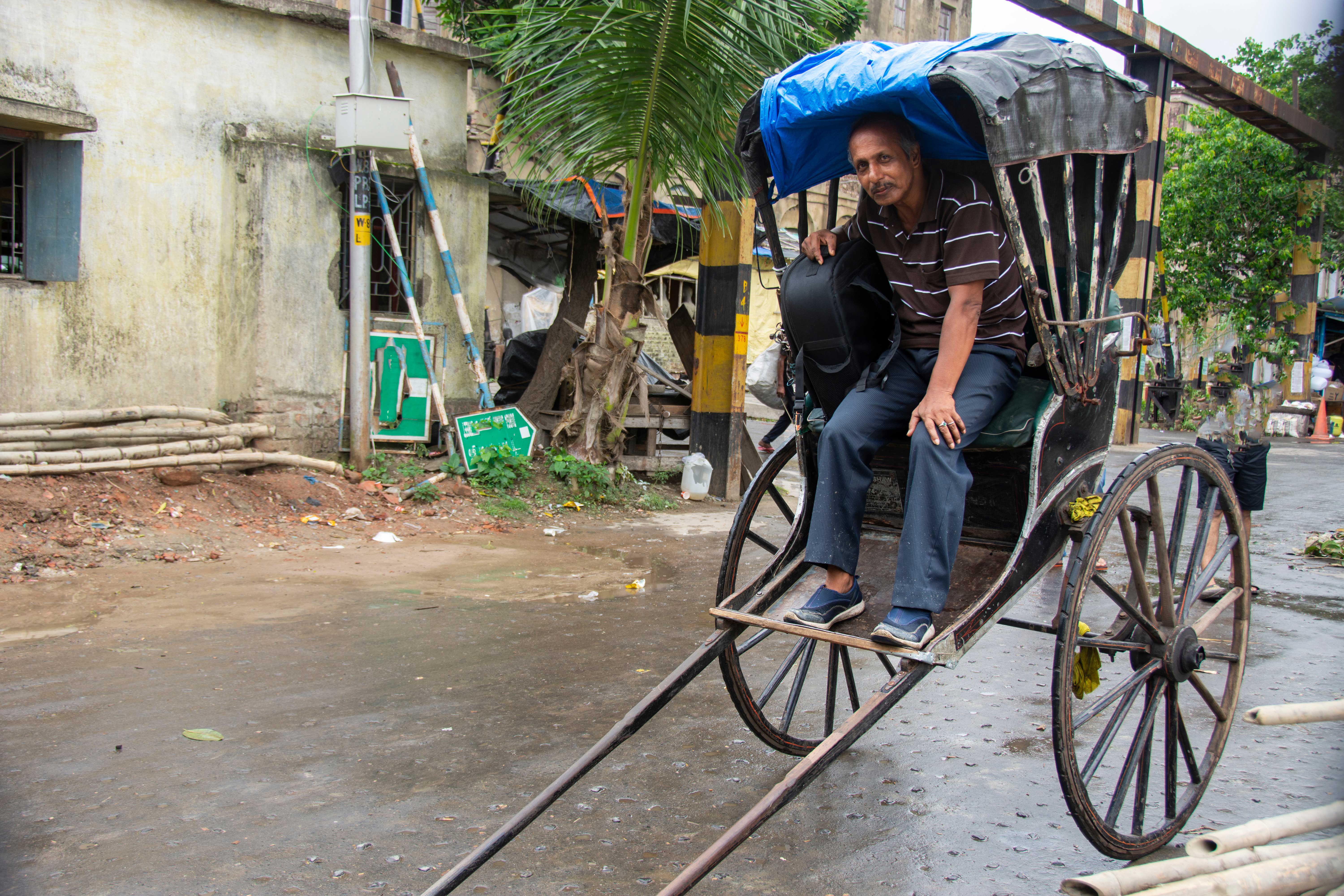 A rickshaw operator sits in the passenger seat of a traditional rickshaw. Engineering a Wacky Auto Race: What is Tuk-Tuk Racing?